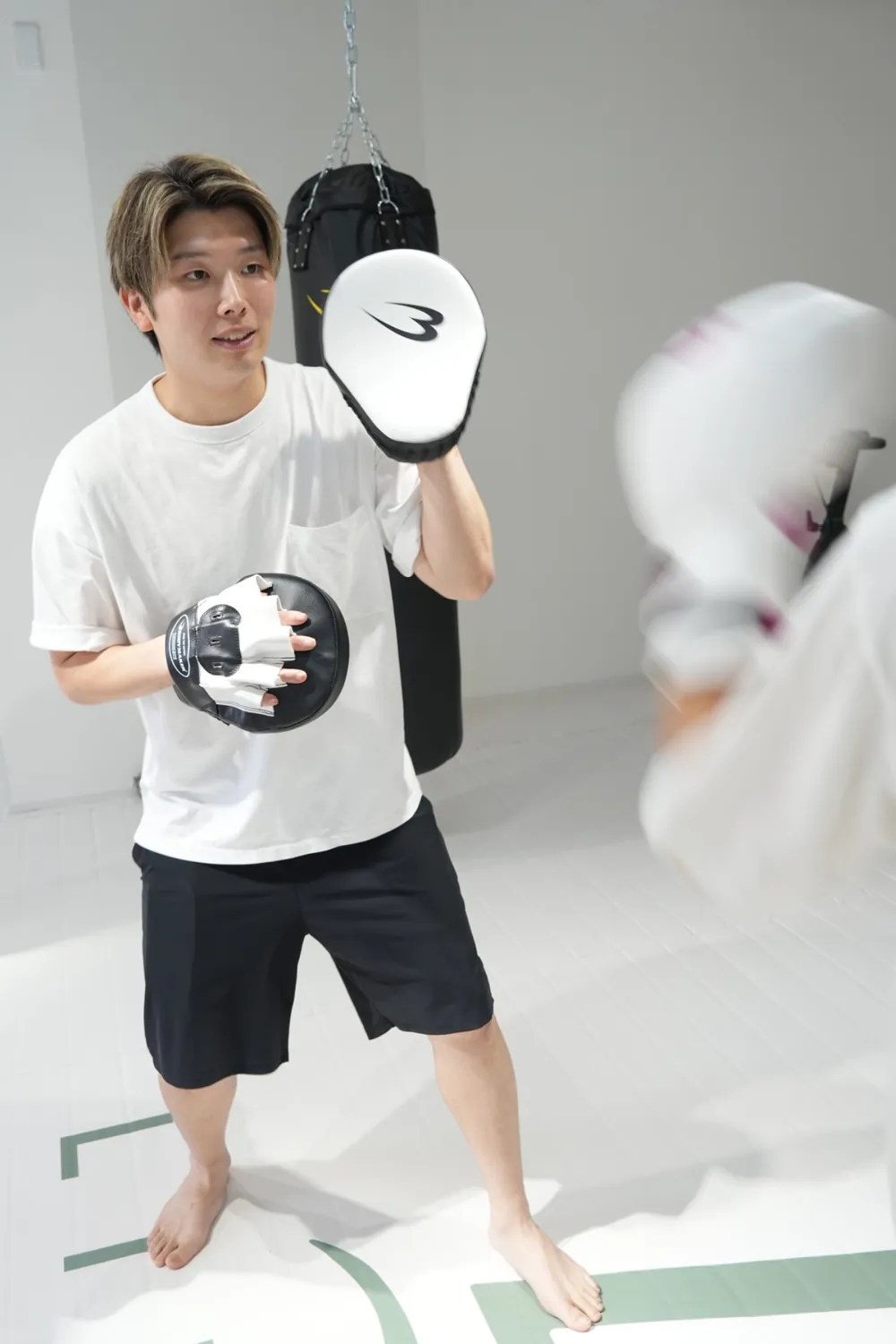 ミットを構えてトレーニングを指導するLINK FIT代表